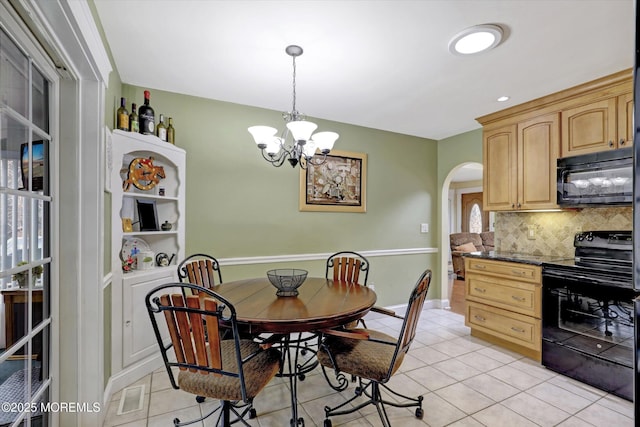 1500 First Ave, Toms River, NJ 08757 - dining space with light tile patterned floors, baseboards, arched walkways, and a notable chandelier
