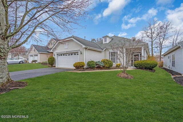 view of front facade featuring a front lawn, an attached garage, and driveway