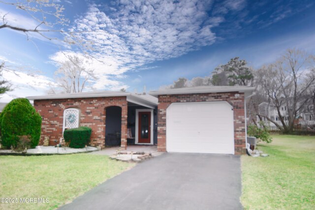view of front of home featuring aphalt driveway, an attached garage, brick siding, and a front yard