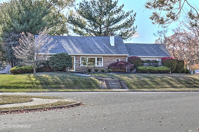 415 Parkview Ave, Ocean Twp, NJ 07712 - view of front facade with a front yard, a shingled roof, stone siding, and a chimney