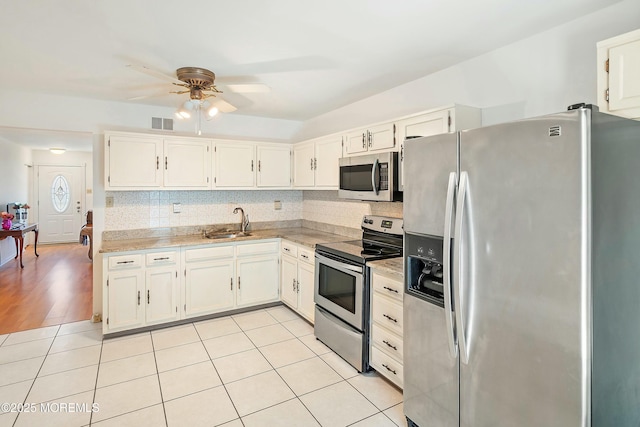 kitchen with visible vents, a sink, backsplash, appliances with stainless steel finishes, and ceiling fan