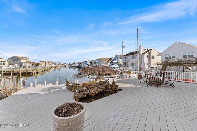 deck with a water view, a residential view, and a dock