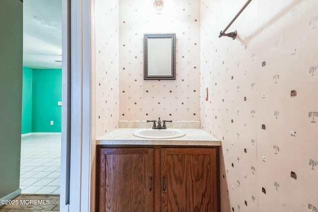 bathroom featuring tile patterned flooring, wallpapered walls, and vanity