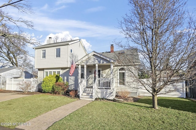 tri-level home with a chimney, a front yard, and fence
