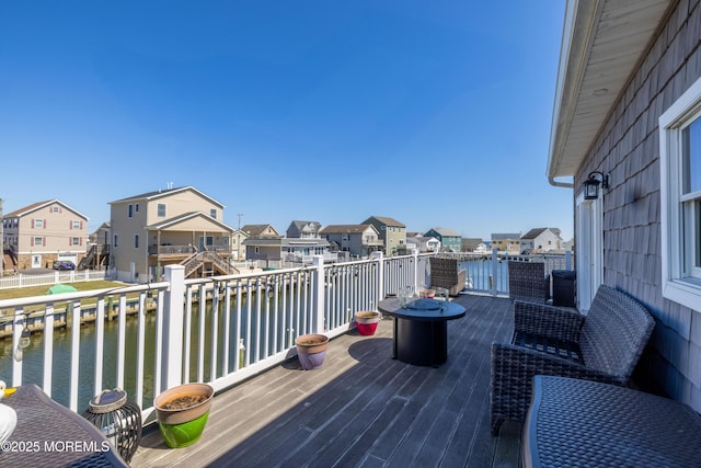 wooden terrace featuring a water view and a residential view