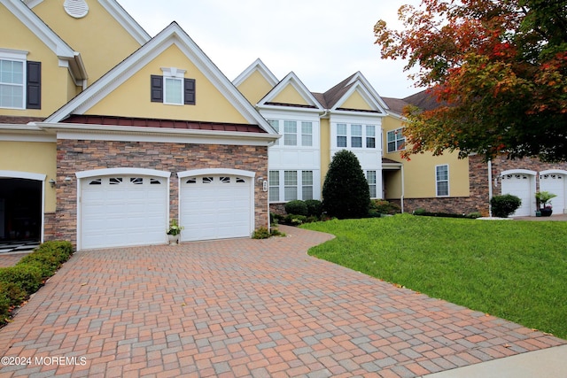 26 Aspen Ln, Tinton Falls, NJ 07724 - view of front of property featuring stone siding, stucco siding, decorative driveway, and a front lawn