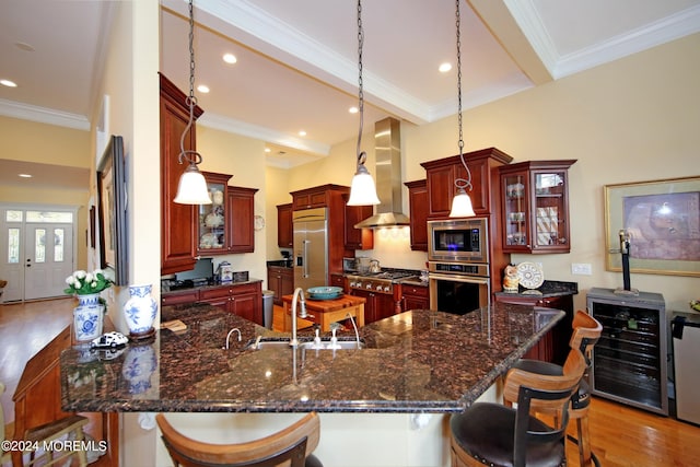 26 Aspen Ln, Tinton Falls, NJ 07724 - kitchen with beverage cooler, built in appliances, a breakfast bar area, and wall chimney range hood