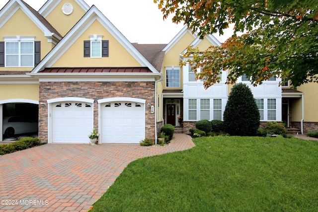 26 Aspen Ln, Tinton Falls, NJ 07724 - view of front of home featuring stone siding, stucco siding, decorative driveway, and a standing seam roof