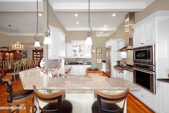 26 Aspen Ln, Tinton Falls, NJ 07724 - kitchen featuring wood finished floors, a sink, built in appliances, crown molding, and wall chimney range hood