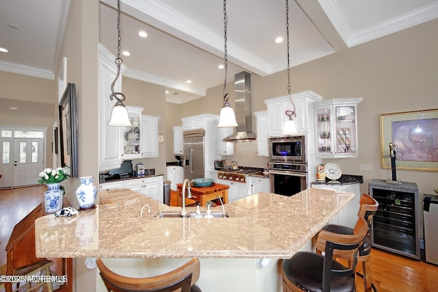 26 Aspen Ln, Tinton Falls, NJ 07724 - kitchen featuring light wood finished floors, a peninsula, wine cooler, built in appliances, and wall chimney exhaust hood