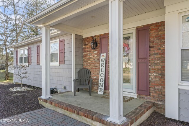4 Whitman Rd, Morganville, NJ 07751 - doorway to property with brick siding and a porch