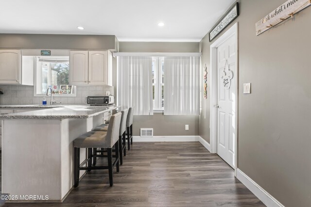 4 Whitman Rd, Morganville, NJ 07751 - kitchen with visible vents, backsplash, baseboards, a kitchen breakfast bar, and white cabinetry
