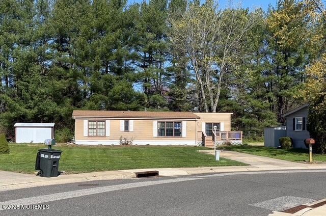 manufactured / mobile home featuring driveway and a front yard