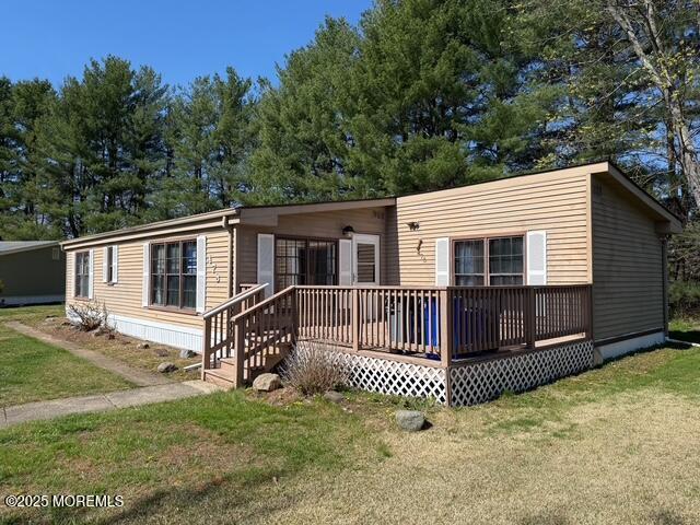 back of house featuring a wooden deck and a yard