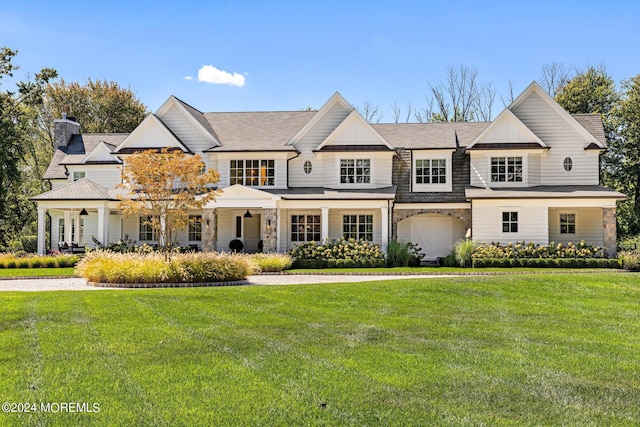 20 Conover Ln, Rumson, NJ 07760 - view of front facade with a chimney, covered porch, a front yard, and stone siding