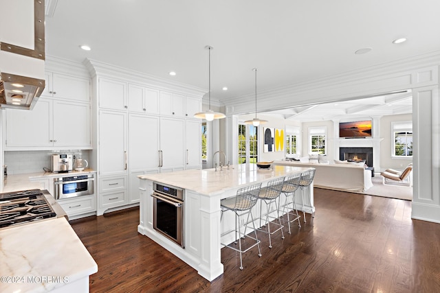 20 Conover Ln, Rumson, NJ 07760 - kitchen featuring recessed lighting, stainless steel appliances, a breakfast bar area, white cabinetry, and a lit fireplace