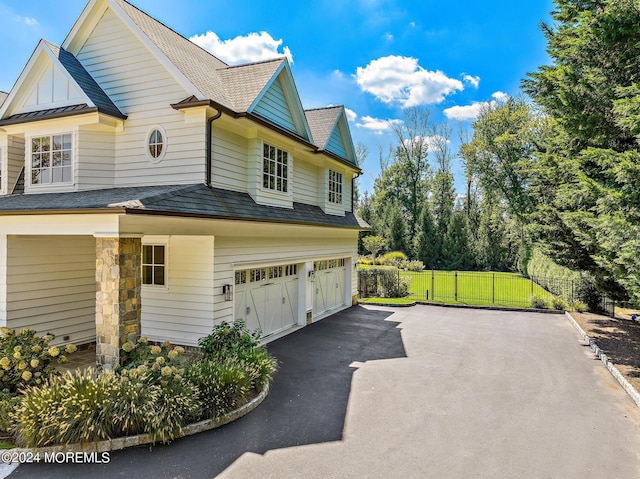 20 Conover Ln, Rumson, NJ 07760 - view of side of property with driveway, fence, a shingled roof, and a garage