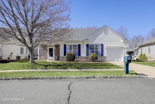 view of front facade featuring a front yard, stone siding, a garage, and driveway