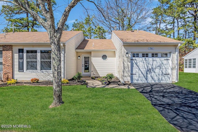 single story home with driveway, a front yard, and a garage