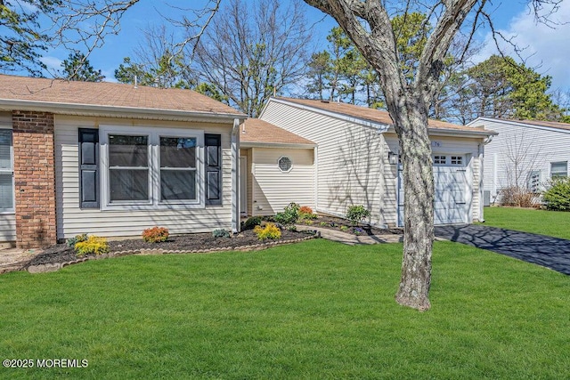view of front of property with aphalt driveway, an attached garage, and a front yard