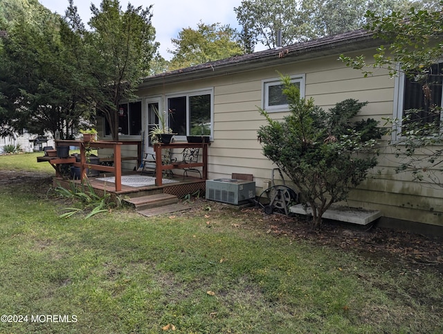 rear view of property with a yard and a deck