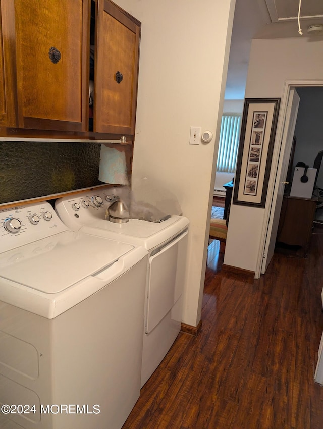 clothes washing area with dark wood-style floors, cabinet space, baseboards, and washer and clothes dryer