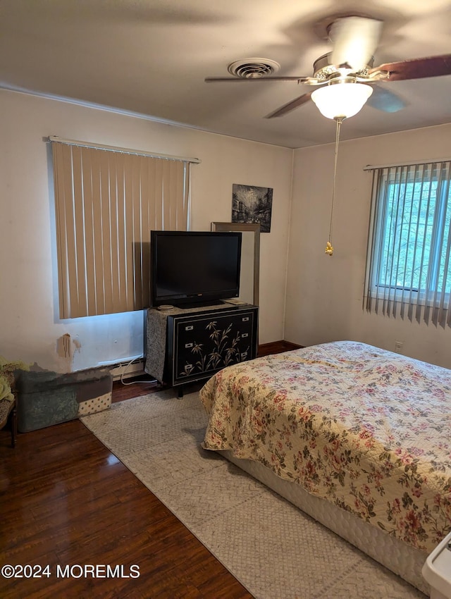 bedroom featuring visible vents, a ceiling fan, and wood finished floors