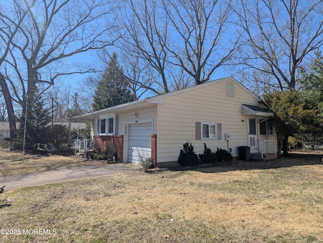 view of front of property featuring aphalt driveway, an attached garage, and a front yard