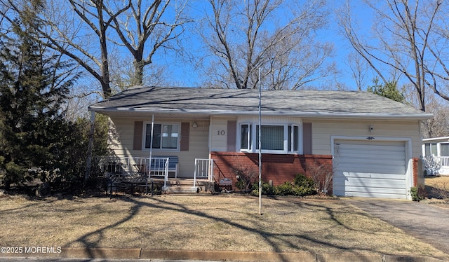 ranch-style house featuring driveway, an attached garage, covered porch, a shingled roof, and brick siding