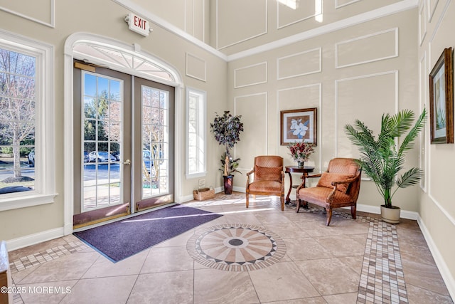 foyer with baseboards, a wealth of natural light, and french doors