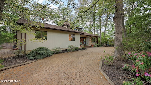 view of front of property featuring central air condition unit and driveway