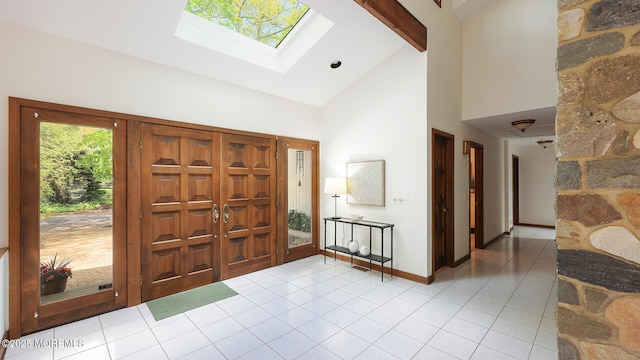 foyer entrance with high vaulted ceiling, tile patterned flooring, a skylight, baseboards, and beam ceiling