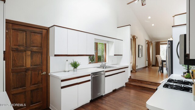 kitchen featuring stainless steel dishwasher, light countertops, white cabinets, recessed lighting, and high vaulted ceiling