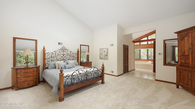 bedroom featuring baseboards, light colored carpet, high vaulted ceiling, and ensuite bathroom