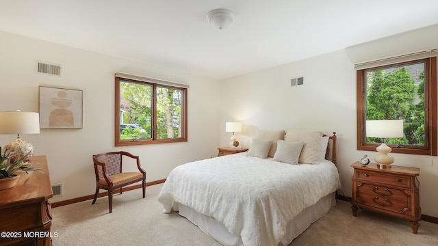 bedroom with light carpet, multiple windows, and baseboards