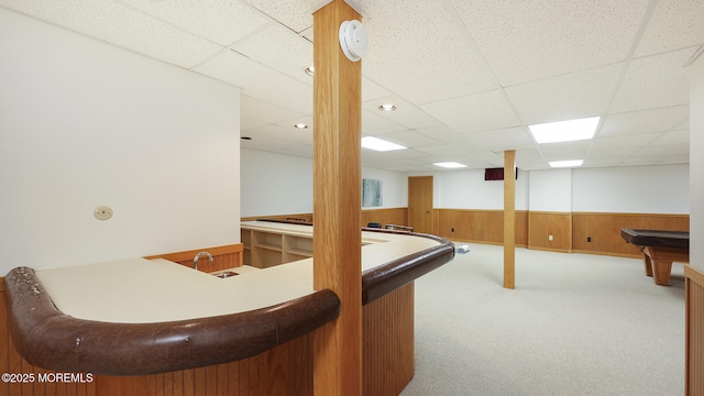 indoor bar with billiards, wainscoting, carpet, a paneled ceiling, and wooden walls