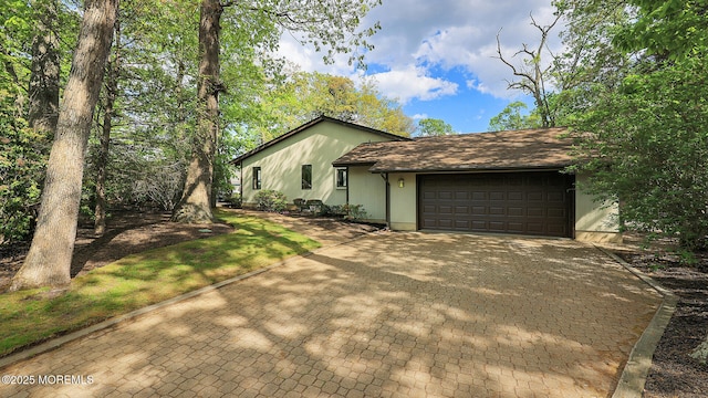 view of side of property with an attached garage and driveway