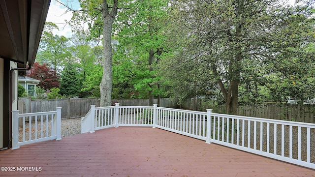 wooden deck with a fenced backyard
