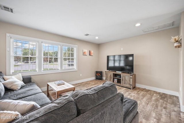 living room featuring baseboards, wood finished floors, and recessed lighting