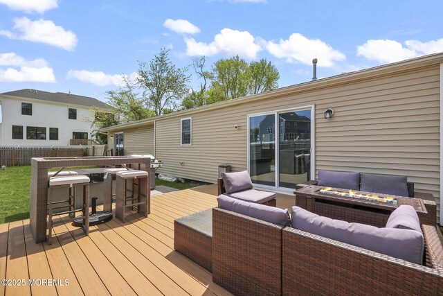 wooden deck with an outdoor living space with a fire pit and fence