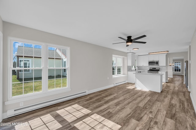 3 Gladstone Ave, Manchester, NJ 08759 - unfurnished living room featuring a baseboard radiator, baseboards, ceiling fan, baseboard heating, and light wood-type flooring