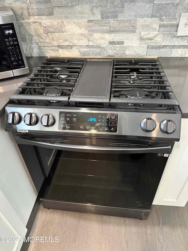 details featuring backsplash and stainless steel appliances
