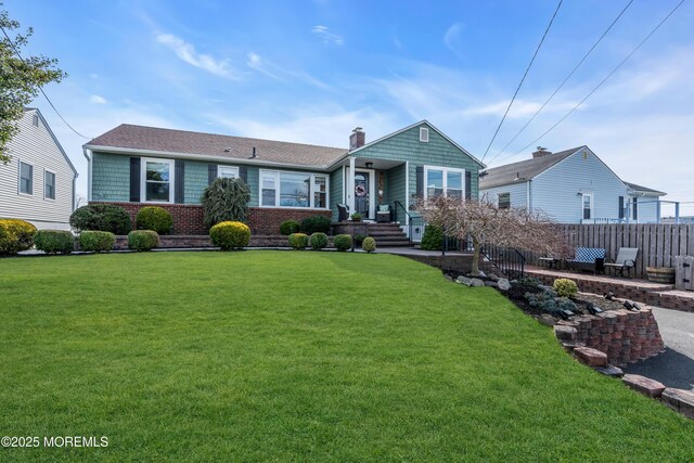 view of front of property featuring a front lawn, a chimney, and fence