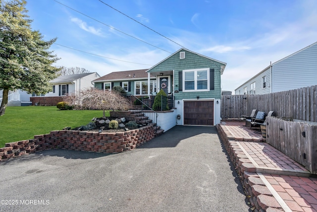 view of front of house featuring fence, driveway, a front yard, and a garage