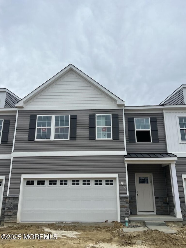 22 Penny Ln, Neptune Township, NJ 07753 - view of front facade featuring a standing seam roof, stone siding, a metal roof, and a garage