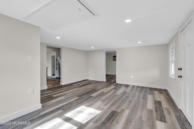 spare room with attic access, recessed lighting, wood finished floors, and baseboards