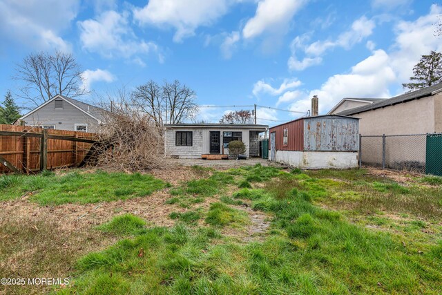rear view of house with an outbuilding and fence