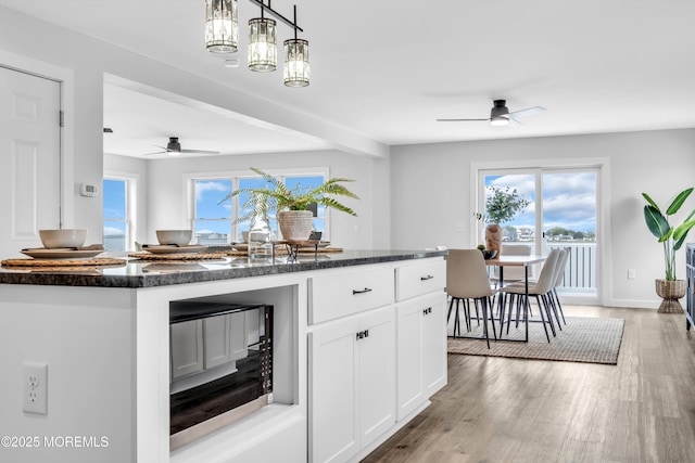 kitchen featuring a ceiling fan, white cabinetry, black microwave, and light wood-type flooring