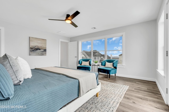 bedroom with light wood-style flooring, ceiling fan, and baseboards