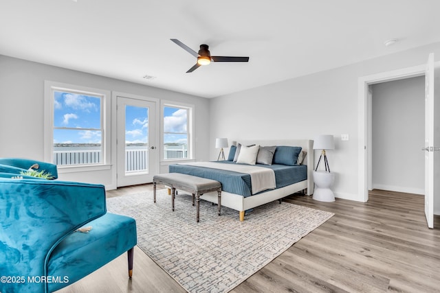 bedroom featuring access to outside, wood finished floors, baseboards, and ceiling fan